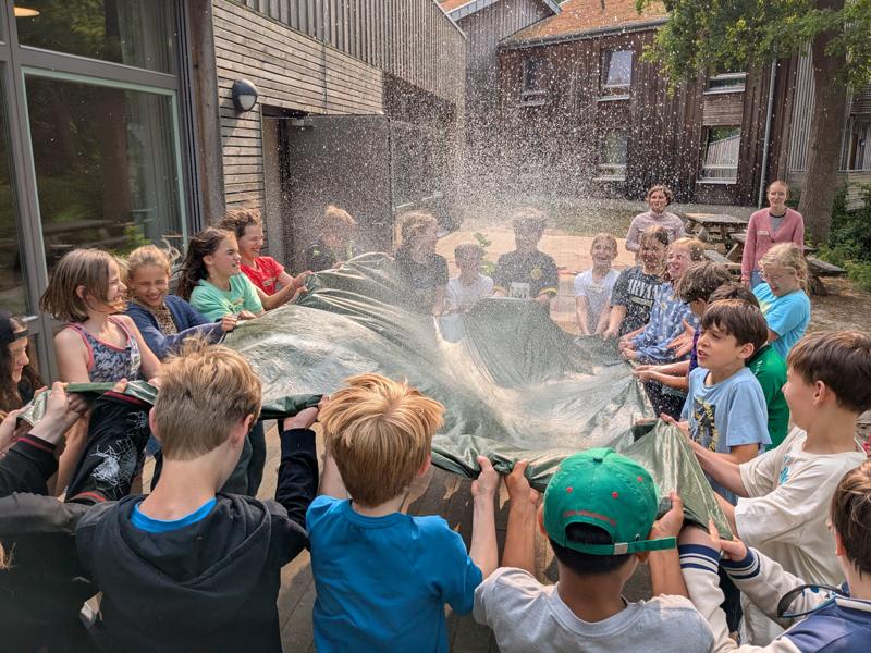 Kinder spielen gemeinsam mit einem Schwungtuch