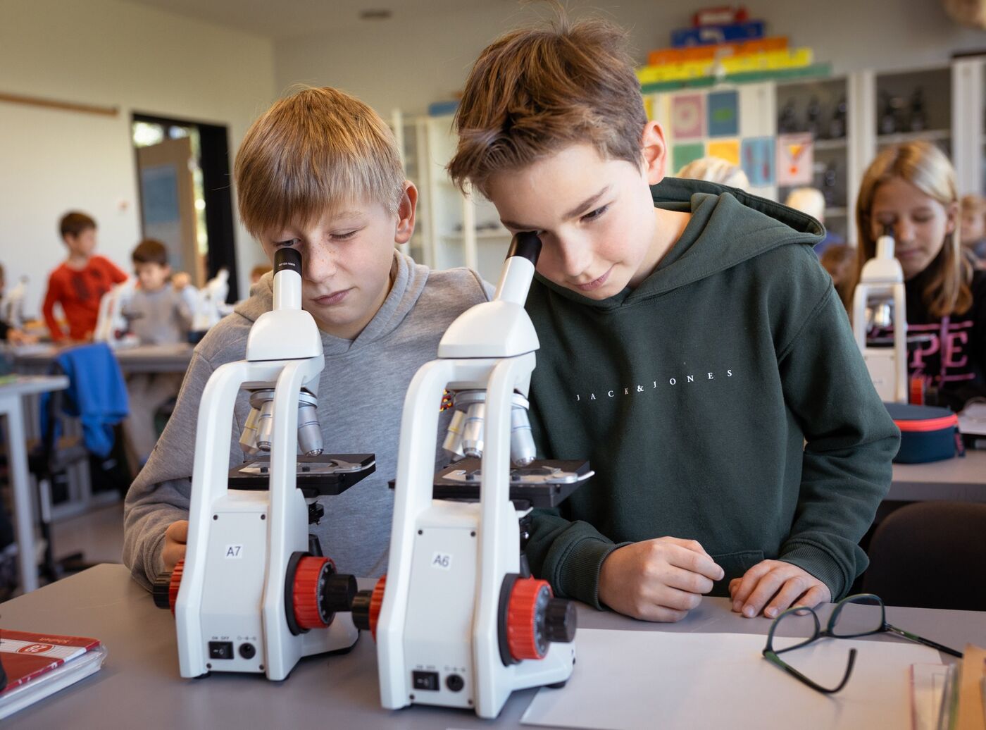 Zwei Jungen mikroskopieren im Biologieraum